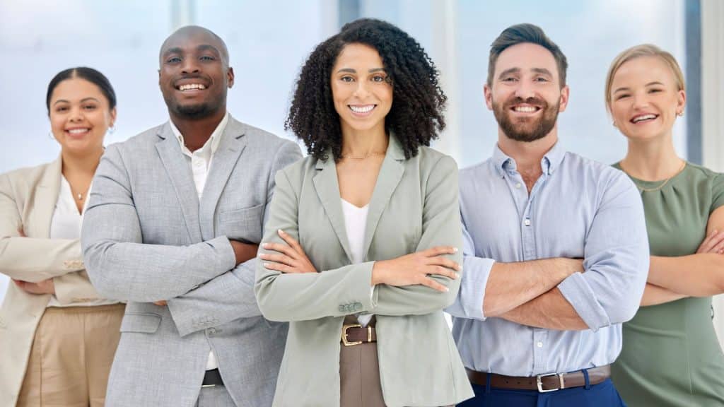 Équipe de 5 personnes souriantes qui croisent les bras